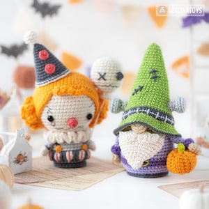 May include: Two crochet dolls: one is a clown with orange hair, a gray hat with red accents, and a white ruff collar holding a white skull balloon; the other is a green-hatted creature with a white beard, purple body, and an orange pumpkin.