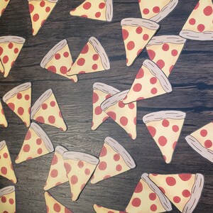 May include: A collection of pizza slice stickers on a dark wood surface. The stickers are yellow with red pepperoni and a brown crust.