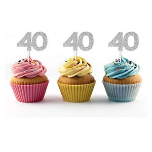 May include: Three cupcakes with silver glitter '40' cake toppers. The cupcakes are frosted in pink, yellow, and blue.