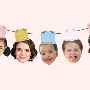 May include: A colorful party banner with five faces of children wearing crowns. The crowns are pink, yellow, blue, white, and pink. The banner is perfect for a birthday party.
