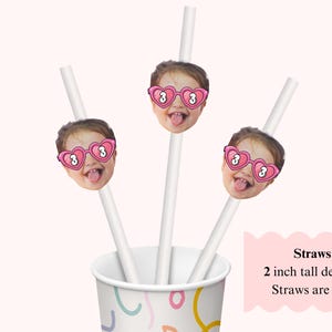 May include: White straws with a child's face wearing pink heart-shaped sunglasses with the number 3. The straws are placed in a patterned cup. The text on the image says "Straws, 2 inch tall designs, Straws are 7 in."