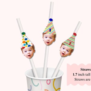 K&ouml;nnte beinhalten: Wei&szlig;e Strohhalme mit dem Gesicht eines Kindes und Partyhut-Designs. Die H&uuml;te haben bunte Muster und die Zahl 1. Die Gesichter sind 4,3 cm hoch. Die Strohhalme sind 17,8 cm lang. Die Strohhalme befinden sich in einem Becher.