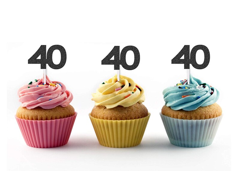 May include: Three cupcakes with black glitter '40' toppers. The cupcakes are frosted in pink, yellow, and blue.
