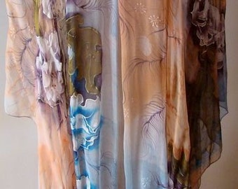 May include: A sheer scarf with a floral design in shades of blue, pink, and brown. The scarf is draped over a mannequin and has a blue flower brooch.