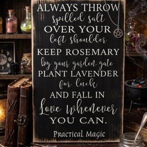 May include: A rectangular black wooden sign with distressed edges featuring white printed text that reads: ALWAYS THROW spilled salt OVER YOUR left shoulder KEEP ROSEMARY by your garden gate PLANT LAVENDER for luck AND FALL IN Love whenever YOU CAN. Practical Magic.