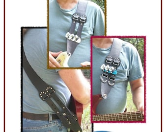 Puede incluir: Un patrón PDF para una correa de guitarra de cuero con un diseño elegante. La correa tiene dos hebillas ajustables y un detalle decorativo en la parte delantera. El patrón está disponible para descargar. © 2017