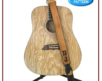 May include: A brown leather guitar strap with the initials "R.J." embossed on it. The strap is attached to an acoustic guitar on a stand. The image includes the text "the Leather Pattern Store" and "Traditional Style Guitar Strap".