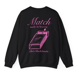 May include: Black sweatshirt with a pink graphic of a matchbox with the text "Match made in heaven" and "Bri's Bachelorette" printed on the back.