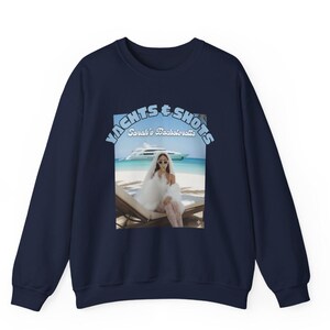 May include: Navy blue sweatshirt featuring a graphic of a woman in sunglasses and a veil on a beach with a yacht. The text "Yachts & Shots, Sarah's Bachelorette" is arched above the image in light blue.