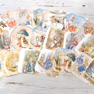 May include: A collection of 20 vintage-style cards featuring illustrations of rabbits in various scenes. The cards are printed on white paper with a light yellow border and have a watercolor-like appearance. The illustrations depict rabbits in a variety of settings, including gardens, forests, and homes. The cards are perfect for scrapbooking, card making, or other craft projects.