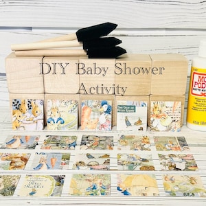 May include: DIY baby shower activity kit with wooden blocks, paintbrushes, and a bottle of Mod Podge Matte. The blocks feature images from the book "The Tale of Peter Rabbit".