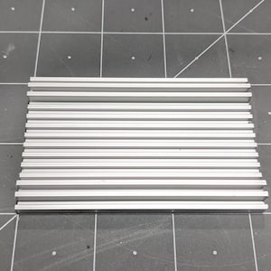 May include: A silver aluminium heatsink with multiple fins for cooling electronic components.