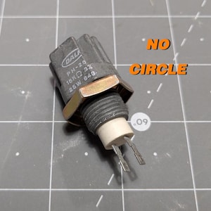 May include: A gray electrical component with the text "DALI PH-25 18K&Omega; 3% 25W 643." printed on it. The component has a gold-colored nut and two metal prongs.