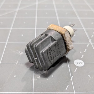 May include: A black and gray automotive sensor with the text "VALEO", "HM-11", "22.5", "MADE", "G7.89", and "M5" printed on the side.
