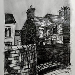 Peut inclure: Un croquis au fusain d'une scène de rue avec des bâtiments et un mur de briques. Les bâtiments ont des cheminées et des fenêtres, et le mur s'incurve autour d'un chemin. L'œuvre est réalisée dans des tons de gris et de noir.
