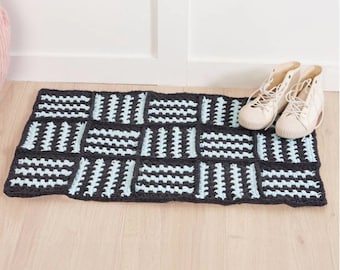 May include: A crocheted doormat with a geometric pattern in shades of blue and gray.