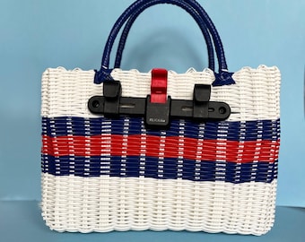 Alforja para bicicleta, cesta tejida de plástico reciclado, color blanco, rojo y azul.