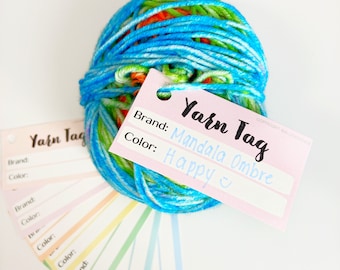 May include: A ball of blue, green, and orange yarn with a pink yarn tag that says "Yarn Tag" and "Brand: Mandala Ombre" and "Color: Happy".