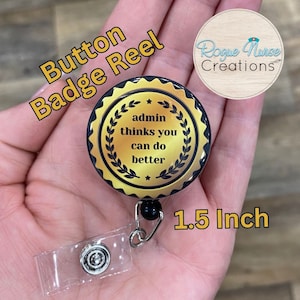 May include: A gold and black button badge reel with the text "admin thinks you can do better." The badge reel is 1.5 inches in diameter and has a clear plastic clip.