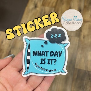 May include: A blue pillow sticker with the text "What Day Is It? Night Shift Problems" and a black cloud with the text "zzz" above it.