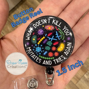 May include: Black button badge reel with the text "WHAT DOESN'T KILL YOU MUTATES AND TRIES AGAIN" and colorful microbe illustrations. The reel is 1.5 inches in diameter and has a clear plastic strap.