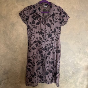 May include: A gray and black floral button-up dress with short sleeves.