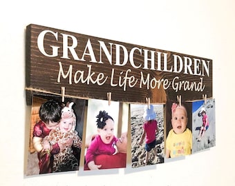 May include: A rustic wooden sign with the text "Grandchildren Make Life More Grand" and a string of clothespins holding photos of children.