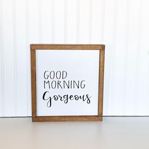 May include: A wooden framed sign with the text "Good Morning Gorgeous" in black calligraphy.