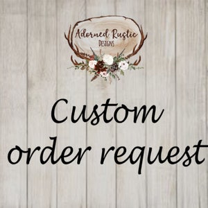 May include: Image features the text "Custom order request" in a cursive font. The text is centered on a light wood-grain background. The Adorned Rustic Designs logo is at the top, featuring a wood slice, antlers, and floral accents.