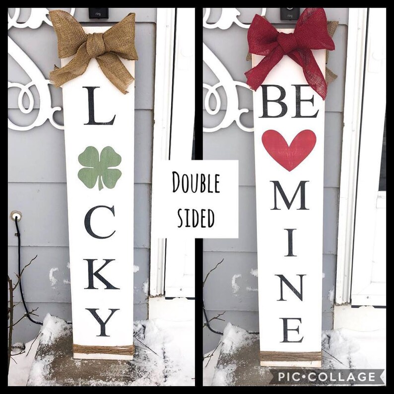 May include: Double-sided wooden sign with two designs. One side says "LUCKY" with a green four-leaf clover. The other side says "BE MINE" with a red heart.
