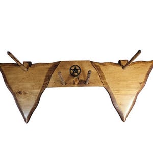 Peut inclure: Un porte-manteau mural en bois rustique avec un motif d'étoile à cinq branches. Le porte-manteau a une finition en bois naturel et comporte quatre crochets en bois.