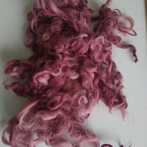 May include: A pile of pink and white wool fibers, likely for spinning or felting.
