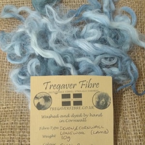 May include: A skein of sky blue long wool yarn, washed and dyed by hand in Cornwall. The yarn is 109 grams and is grown by Tregondale. The label reads "Tregaver Fibre, Sustainable Fibres, Ethically Farmed, Tregavfibre.co.uk, Devon & Cornwall Longwool (Lamb)"