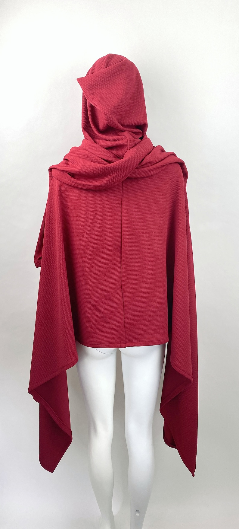 showing the back of the cloak - back reached a range of lengths depending on height, ranging from small of back to mid-buttocks