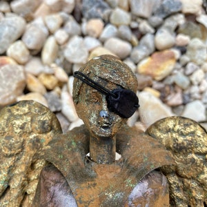 a small statue displaying the mini eyepatch over its eye