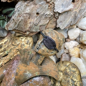 a small statue displaying the mini eyepatch over its eye