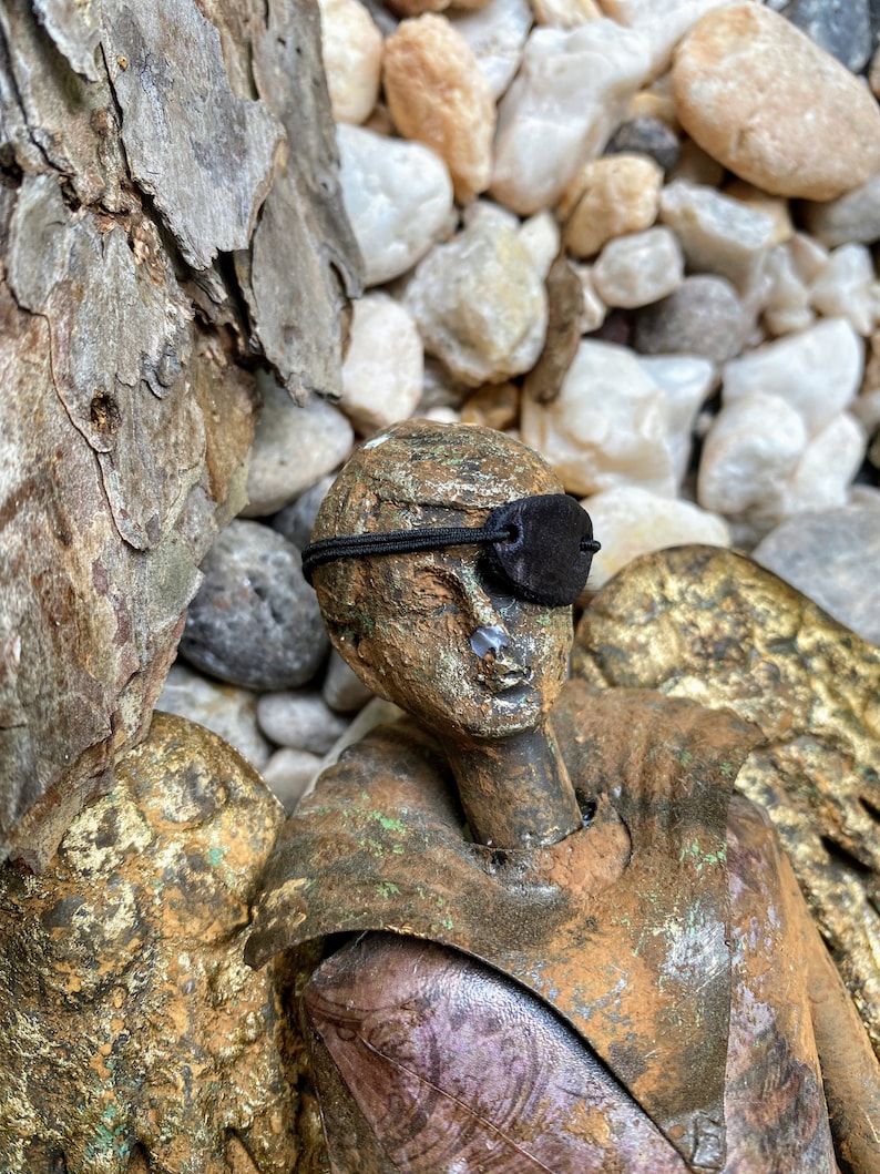 a small statue displaying the mini eyepatch over its eye