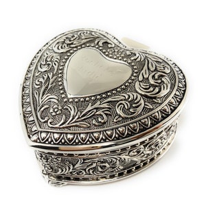 May include: A silver heart-shaped trinket box with an ornate design and an engraved inscription that reads "Audie Mae and David".