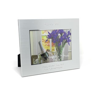 May include: Silver picture frame with a brushed finish. The frame holds a 5x7 inch photo and has a personalized inscription that reads "2013 Happy Wishes!" and "Love, Lyle and your family".