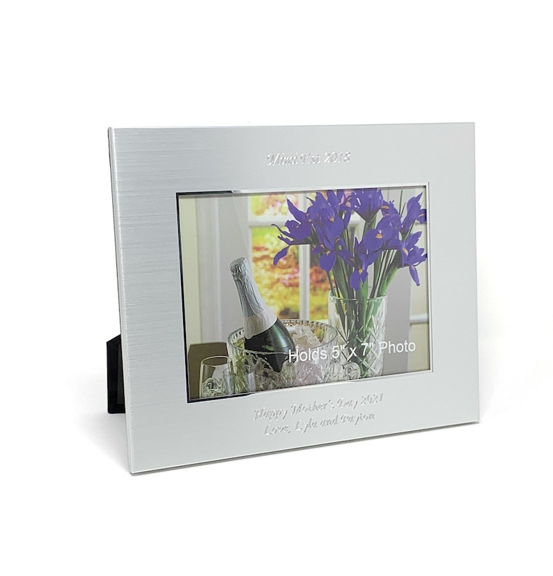 May include: Silver picture frame with a brushed finish. The frame holds a 5x7 inch photo and has a personalised inscription that reads "2013 Happy Wishes!" and "Love, Lyle and your family".