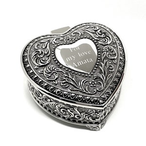 May include: Silver heart-shaped trinket box with an ornate design and an engraved message that reads "For my love Amata".
