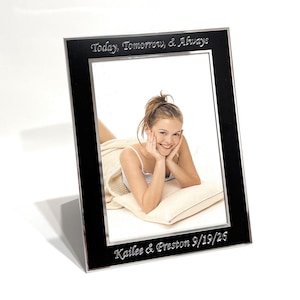 May include: A rectangular black picture frame with a silver inner border. The top of the frame is engraved with the text "Today, Tomorrow, & Always" and the bottom is engraved with "Kailee & Preston 9/19/26". The frame holds a photo of a person.