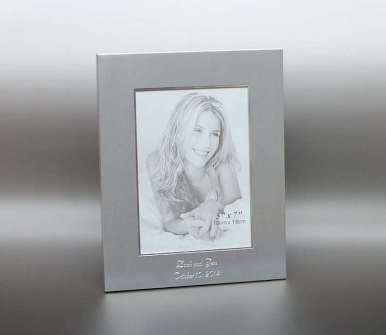 May include: Silver picture frame with a 5x7 inch (13cm x 18cm) opening. The frame has a personalised inscription that reads "Josh and Jess October 13, 2014".