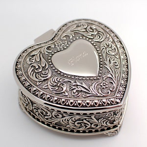 May include: Silver heart-shaped trinket box with an ornate design and the name "Fiona" engraved on the lid.
