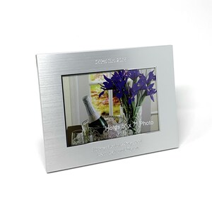 May include: Silver photo frame with a brushed finish. The frame holds a 5x7 inch photo and has the date "July 25, 2022" and the text "Happy Anniversary Day 2022 Love Always and Forever" engraved on the front.