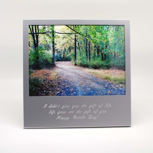 May include: A silver picture frame with a photo of a path through a forest. The frame has an engraved message that reads: "I didn't give you the gift of life, life gave me the gift of you. Happy Gotcha Day!"