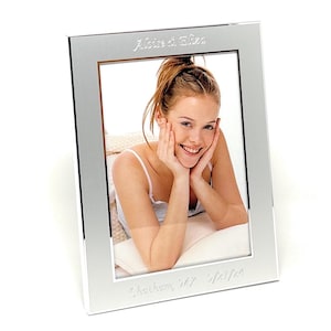 May include: Silver photo frame with a personalized inscription that reads "Alice & Eliza,  Charleston, SC 5/23/24".