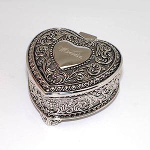 May include: Silver heart-shaped trinket box with an ornate floral design and the name "Miranda" engraved on the lid.