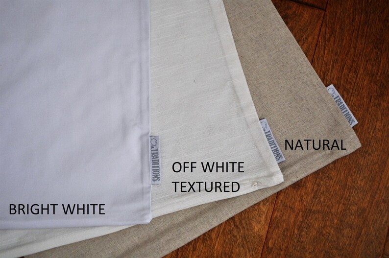 May include: Three fabric swatches in varying shades of white and beige are displayed. The swatches are labeled "Bright White", "Off White Textured", and "Natural". Each swatch has a small tag that reads "Traditions".