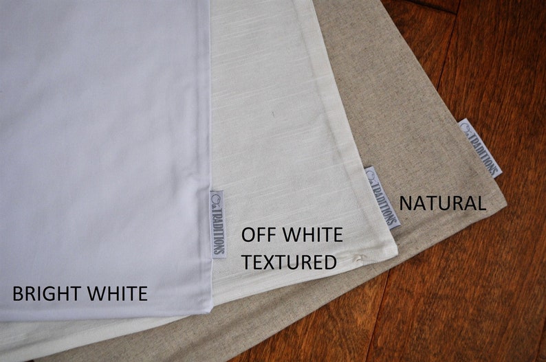 May include: Three fabric swatches in varying shades of white and beige are displayed. The swatches are labeled "Bright White", "Off White Textured", and "Natural". Each swatch has a small tag that reads "Traditions".